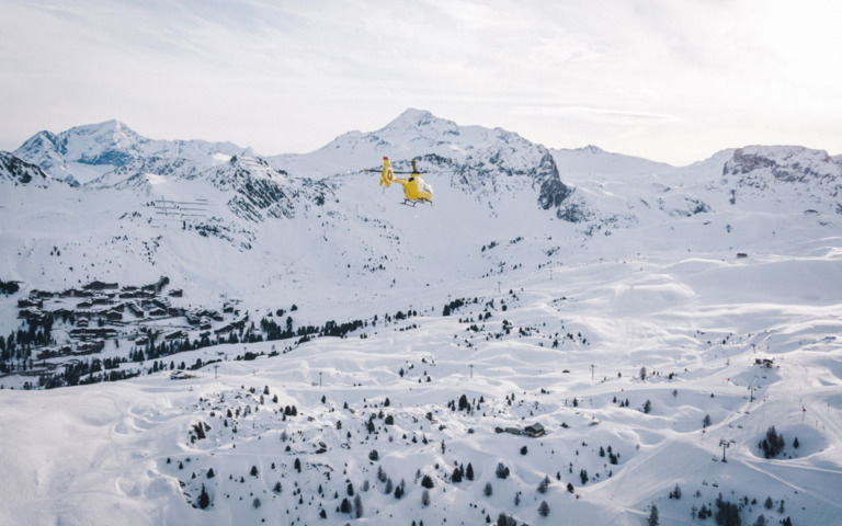 Hélicoptère vole au dessus de la station de ski